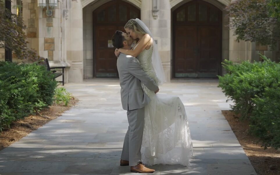 a happy couple kissing at their wedding outside