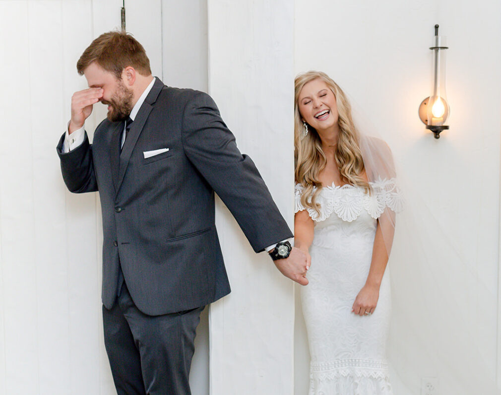 bride and groom laughing, holding hands
