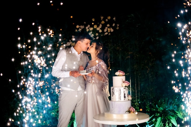 the bride and groom kissing in front of the magic lights