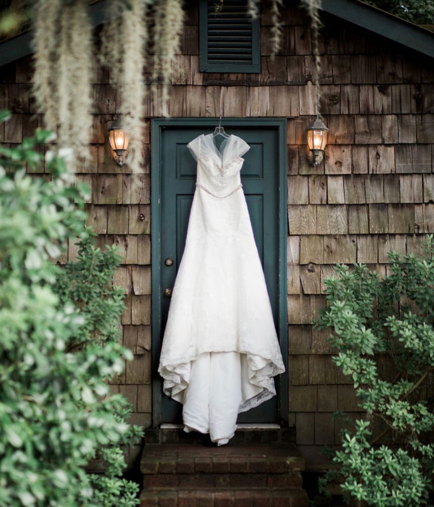 wedding dress hanging on the door of the house