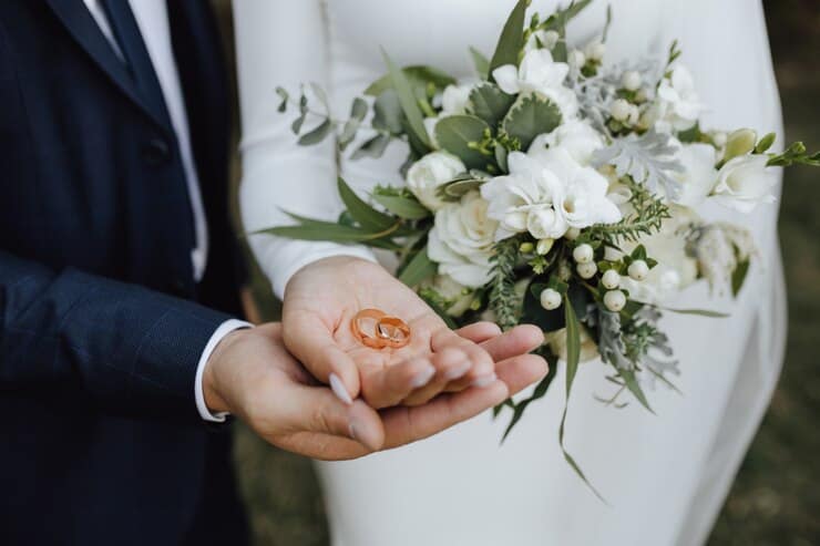 Wedding Bands in the Hands with Beautiful Bouquet