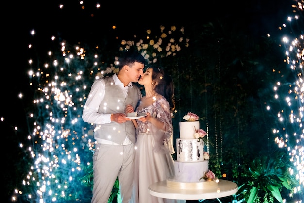 the bride and groom kissing in front of the magic lights