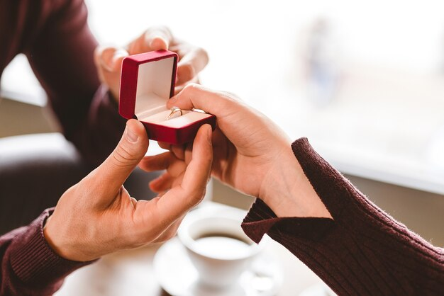 hands holding a ring in a box